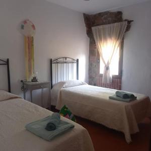 une chambre d'hôtel avec deux lits et une fenêtre dans l'établissement Casa rural viñas perdidas, à Béjar