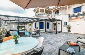 an outdoor patio with a table and chairs at אחוזת סנטוריני - וילה מהממת עם בריכה מחוממת וג'קוזי בעין יעקב in ‘Ein Ya‘aqov