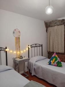 - une chambre avec 2 lits et une horloge murale dans l'établissement Casa rural viñas perdidas, à Béjar 19 autres photos