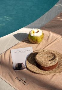 a donut and a hat on a towel next to a pool at naravi gardenandpool kohlarn in Ko Sak