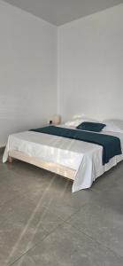 a bed with white sheets and a blue blanket at La Fleur Doré F3 Le Vauclin in Le Vauclin