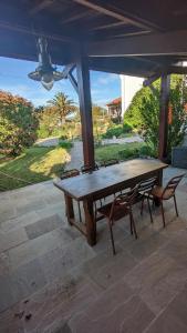 ein Holztisch und zwei Stühle auf einer Terrasse in der Unterkunft Lau Haizeak Meublé 3 étoiles Ascain in Ascain