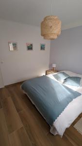 ein Schlafzimmer mit einem großen Bett und einem Kronleuchter in der Unterkunft Lau Haizeak Meublé 3 étoiles Ascain in Ascain