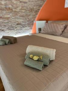 a bed with two pillows and a ring on it at Dimora Sant'Anna Family Suite in Bernalda +35 photos