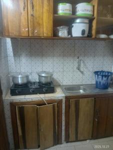 Una cocina con una estufa con ollas y sartenes encima. en Bobo LAFIA RESIDENCE MEUBLEE, en Bobo-Dioulasso