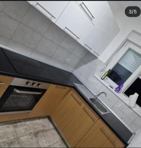 een keuken met witte kasten, een gootsteen en een raam bij Dream House Zvornik in Zvornik