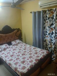 1 dormitorio con 1 cama con manta de flores en Bobo LAFIA RESIDENCE MEUBLEE, en Bobo-Dioulasso
