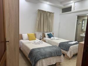 two beds in a small room with a bathroom at 4 Bed Maisonette Close to Mater Dei in Birkirkara