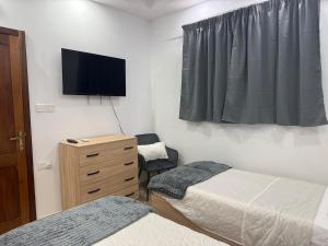 a bedroom with two beds and a television on the wall at 4 Bed Maisonette Close to Mater Dei in Birkirkara +3 photos