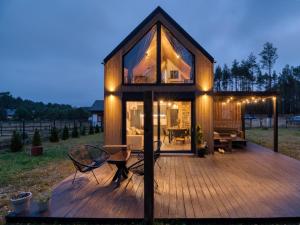 a large wooden deck with a glass house at Bliżej Lasu in Śliwice
