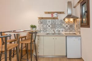 a kitchen with a sink and a counter with stools at Luxury Sirens Fresh in Limenas