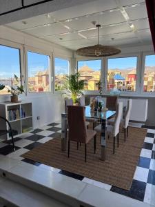 een eetkamer met een tafel en stoelen op een geruite vloer bij ATICO AMBERES SEAVIEW PENTHOUSE - Torrox Costa in Castillo Bajo
