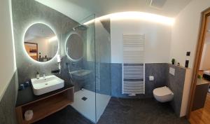 Un baño con lavabo, inodoro y espejo. en Hotel Krone, en Morter 21 fotos más