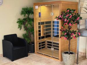 a chair and a glass cabinet with a plant at Mon Petit Paradis avec Piscine Intérieure Privative Chauffée et climatisation in Lournand