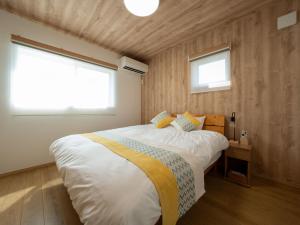 una camera con un grande letto e due finestre di Stationvilla-Nagoyaport a Nagoya