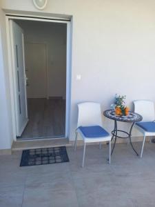 a patio with two chairs and a table with oranges on it at Apartmani Dropulić in Opuzen