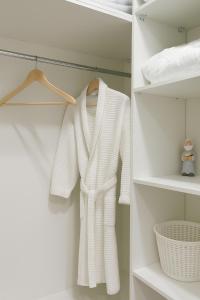 een witte trui hangt in een kast bij ЖК Атамура in Promyshlennyy