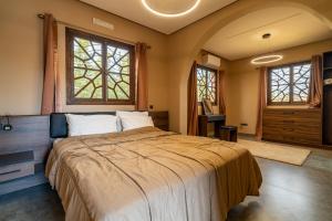 ein Schlafzimmer mit einem großen Bett und zwei Fenstern in der Unterkunft Villa a Marrakech with private pool in Marrakesch + 60 Fotos