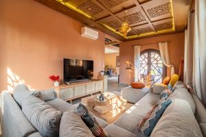 ein Wohnzimmer mit Sofa und Fernseher in der Unterkunft Villa a Marrakech with private pool in Marrakesch