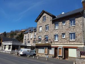 una furgoneta estacionada frente a un edificio de piedra en Les Chenets, en Chambon-sur-Lac