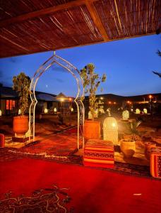 a room with an arch and a red carpet at Desert Pearl Camp in Merzouga