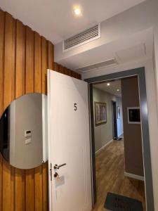 una stanza con una porta bianca e uno specchio di La Villa Bnb a Tirana