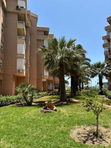 een gebouw met palmbomen voor een tuin bij ATICO AMBERES SEAVIEW PENTHOUSE - Torrox Costa in Castillo Bajo