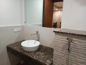 a bathroom with a white sink on a counter at Gold Crest Premium Hotel Serviced Apartments DHA Phase 4 Lahore in Lahore