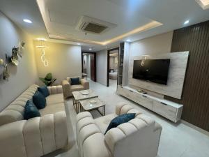 a living room with couches and a flat screen tv at Gold Crest Premium Hotel Serviced Apartments DHA Phase 4 Lahore in Lahore