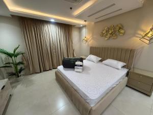 a bedroom with a bed with a suitcase on it at Gold Crest Premium Hotel Serviced Apartments DHA Phase 4 Lahore in Lahore