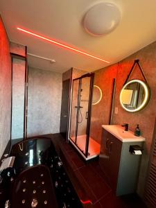 a bathroom with a tub and a sink and a mirror at Boutique Spa apartment with Balcony & River Views in Norwich
