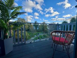 a chair sitting on a deck with a view at Boutique Spa apartment with Balcony & River Views in Norwich