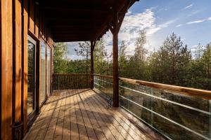 a balcony of a house with a view of the woods at Kalliomaja Villa Lummelahti in Savitaipale +16 photos