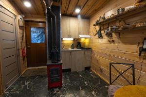 a kitchen with a woodburning stove in a room at Kalliomaja Villa Lummelahti in Savitaipale