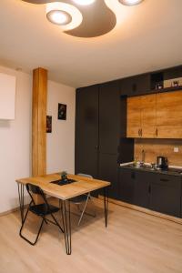 a kitchen with a wooden table in a room at Greenside Apartment in Pristina