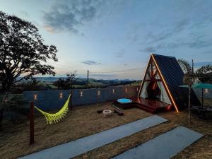 a small playground with a tent and a hammock at Chalé mirante do Sol in Socorro