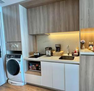a kitchen with a sink and a washing machine at Home tai gia in Quy Nhon