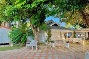 een huis met twee witte stoelen en een boom bij I Am Chiang Rai in Ban Cham Bon