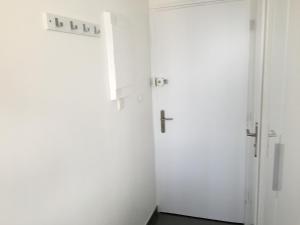 une chambre avec deux armoires blanches et une croix sur la porte dans l'établissement Studio face Mer - Village Naturiste - Cap d'Agde, au Cap d'Agde