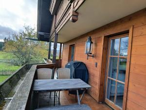 a wooden deck with a wooden table and chairs at Idyllische Maisonettewohnung mit Bergblick in Irschenberg