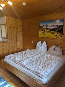 a bedroom with a bed in a wooden room at Idyllische Maisonettewohnung mit Bergblick in Irschenberg