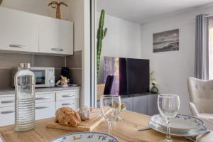 Una cocina con una mesa con copas de vino encima. en Escapade à Bandol balcon verdoyant et plage à deux pas, en Bandol