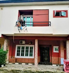 een rood-wit huis met een balkon bij Short Let Apartments in Lagos Business School Lekki Ajah in Lekki