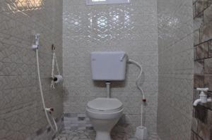 a bathroom with a white toilet in a stall at Bulu Apartments in Kilifi +7 photos
