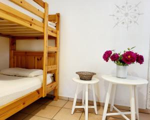 a bedroom with a bunk bed and two tables with flowers at Terre di Pedemonte Centovalli am Strand von Tegna in Tegna