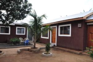 a house with a palm tree in front of it at Bulu Apartments in Kilifi