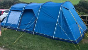 a blue tent on the grass in a field at kolkumalai tent stay in Suryanelli +2 photos