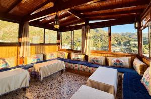 a train room with couches and tables and windows at Hôtel Koutoubia in Chefchaouen