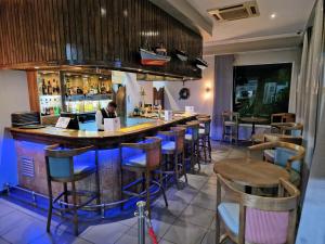 um bar com cadeiras e um homem sentado num balcão em Lüderitz Nest Hotel em Lüderitz