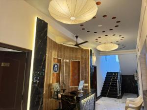 Un vestíbulo con una escalera, dos luces y un techo. en La Coromandel Luxury - TIE, en Pondicherry